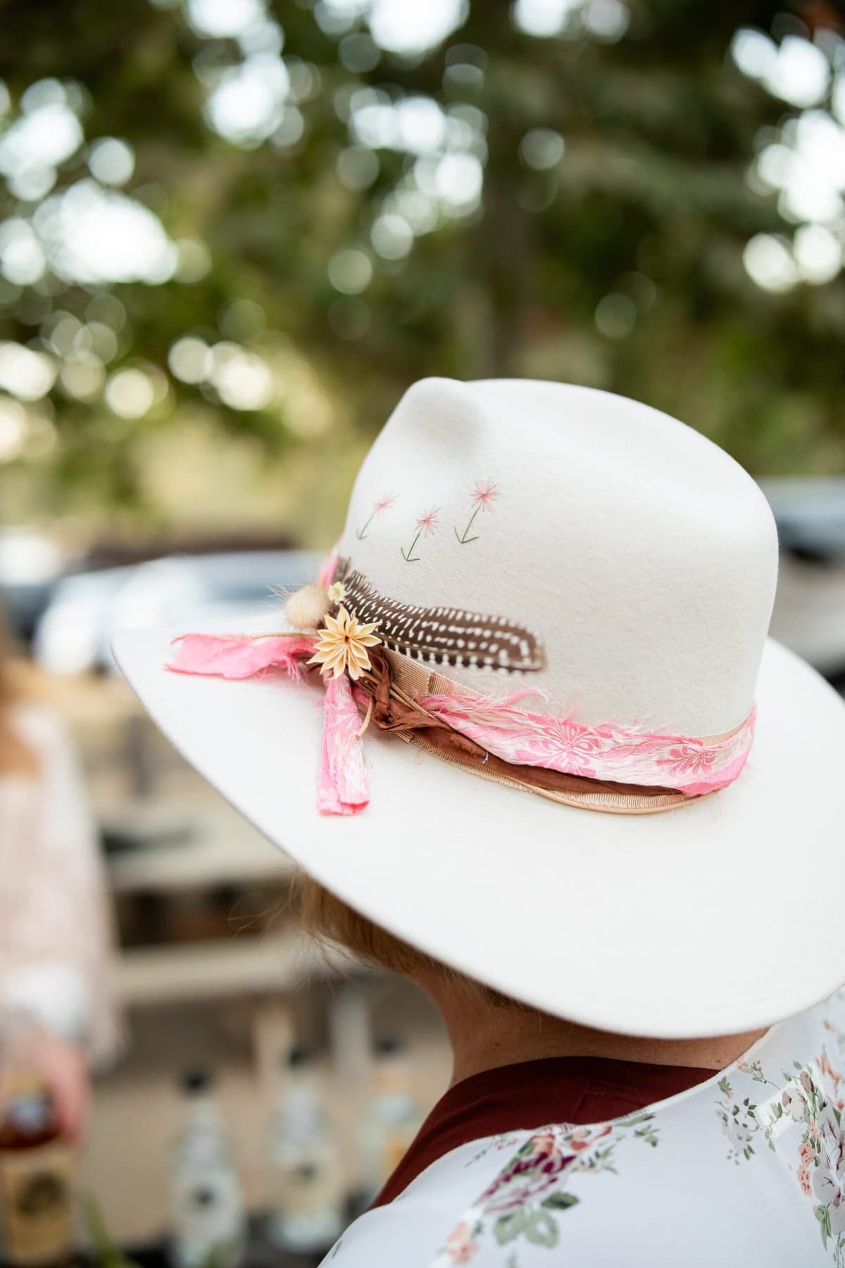 close up of cowgirl hat with ribbon round, flower around band