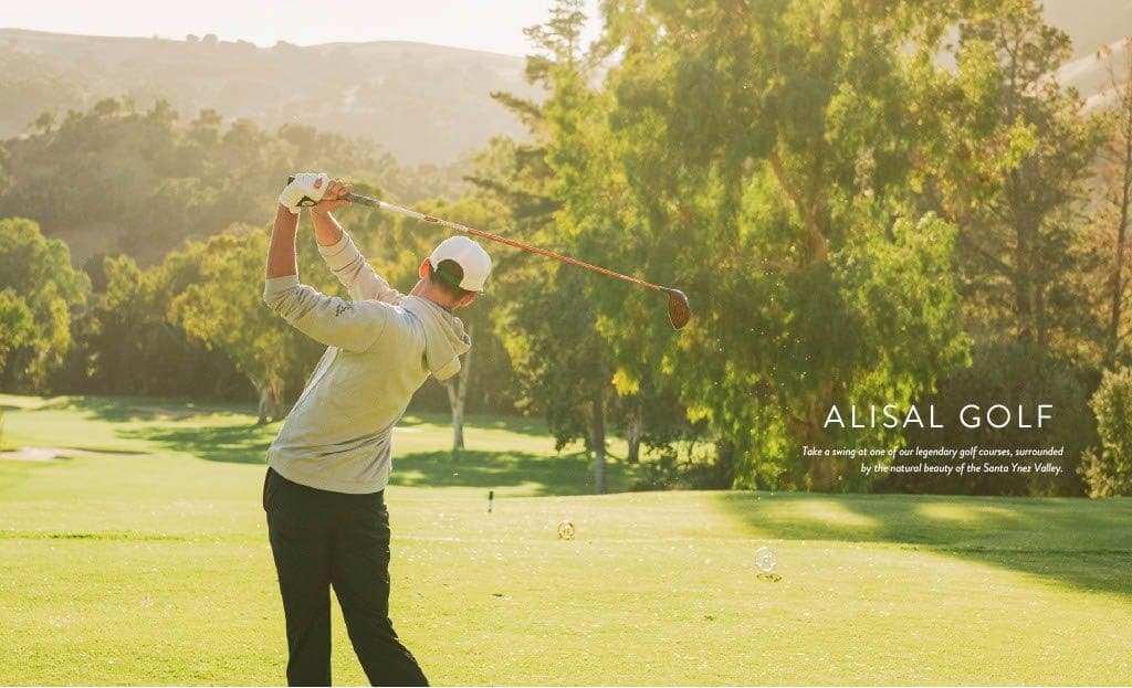 man posing at the end of a golf swing with golf club over head