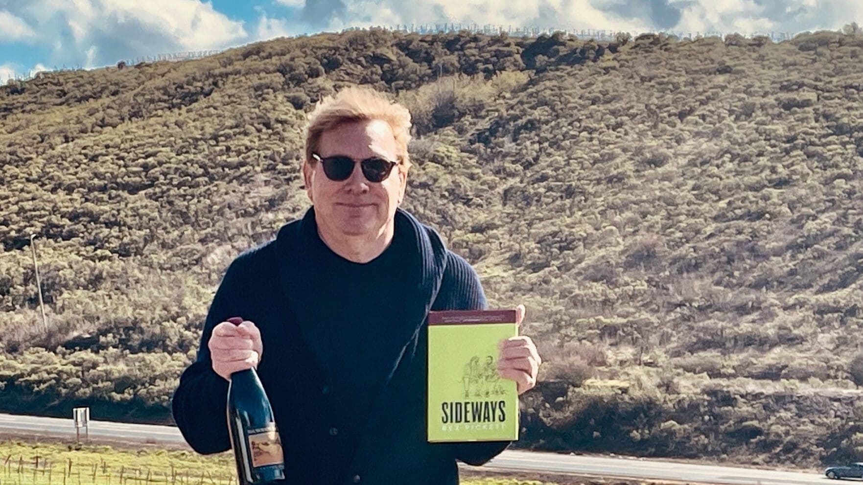 man holding bottle of wine and Sideway book