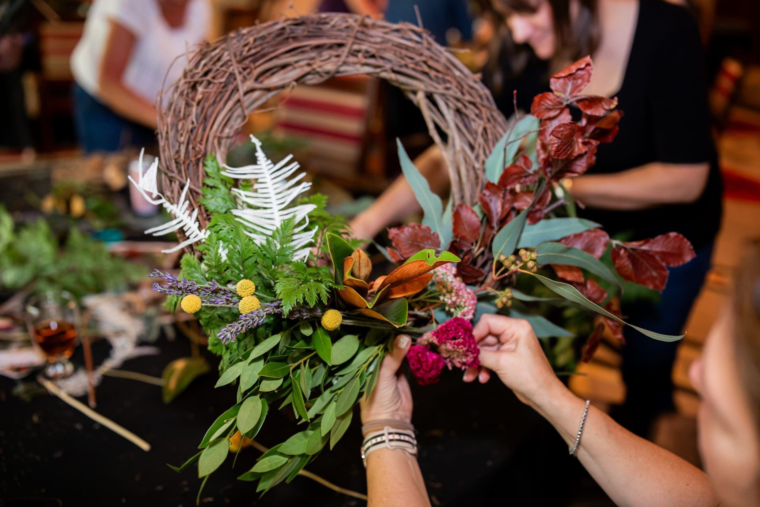 person making wreath with flowers and leaves