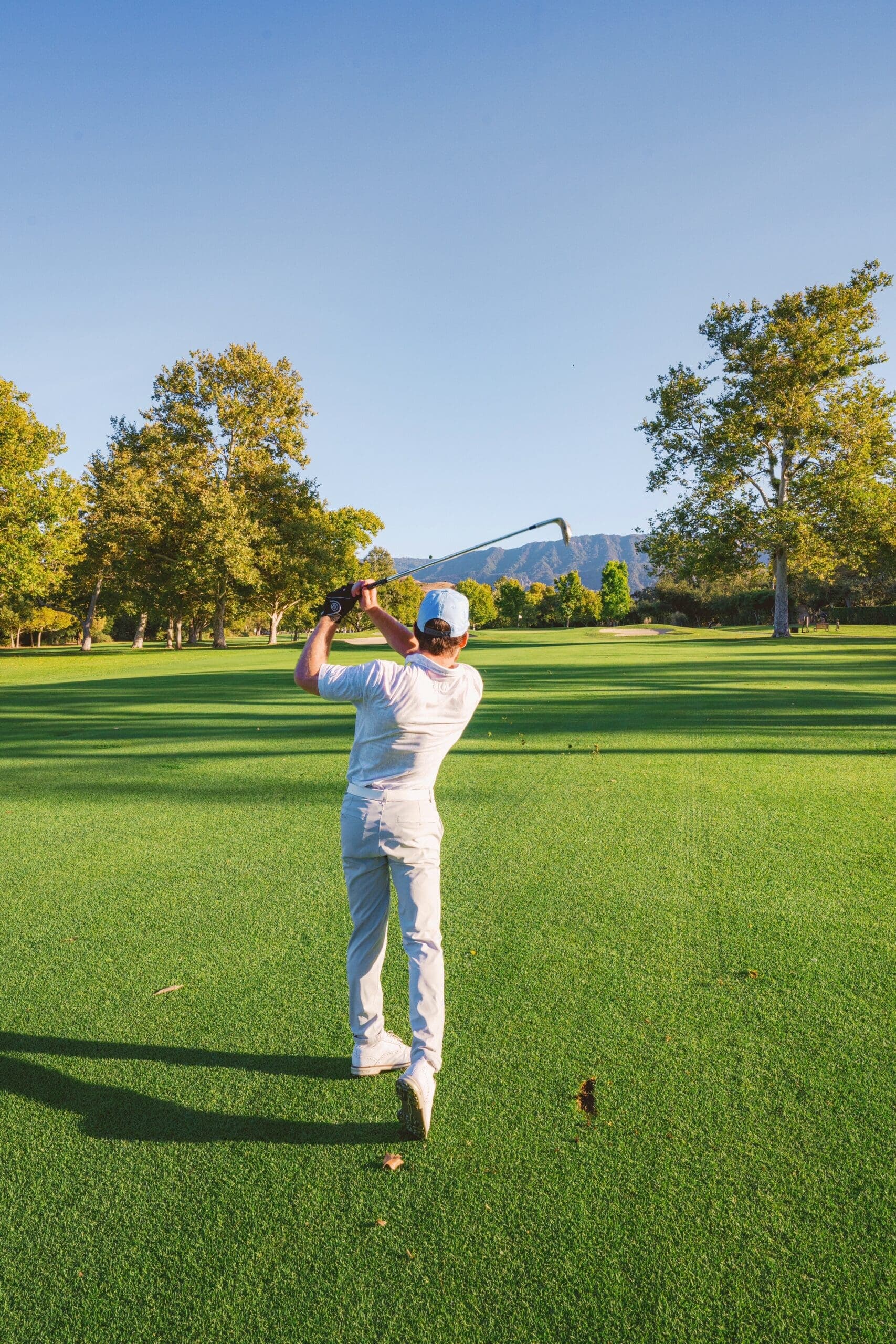 person swinging golf club