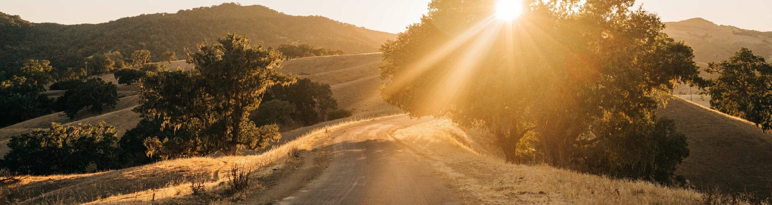 view of road and hills as sun sets